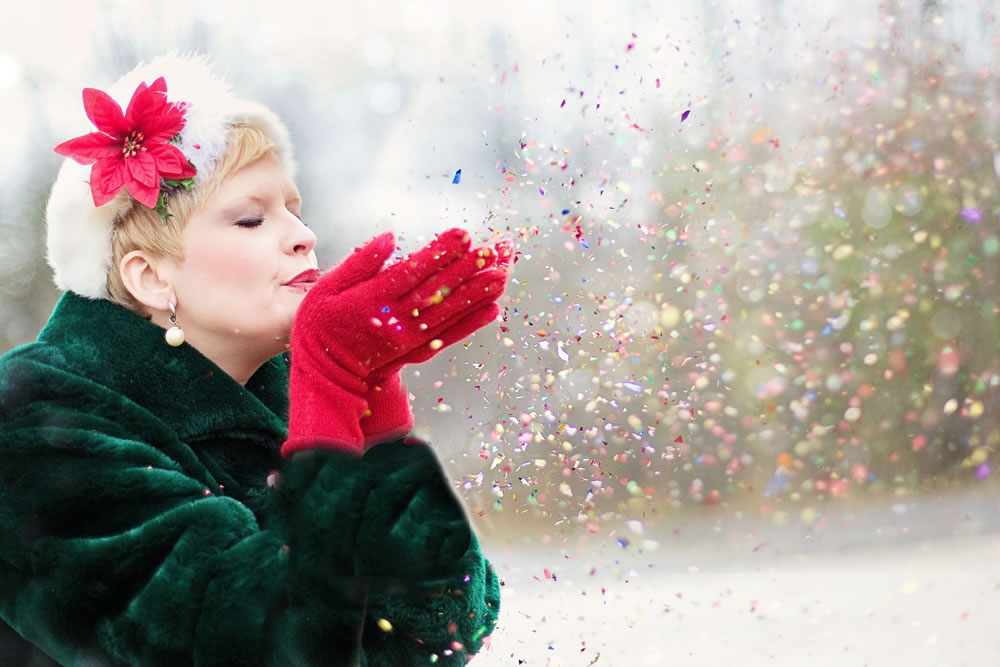 young woman blowing confetti