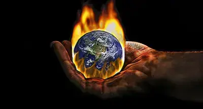 Global warming. The Earth is on fire in someone's charred hand.