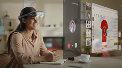 A person is sitting at a desk wearing an AR headset. An AR overlay of an internet shopping site appears in front of them.