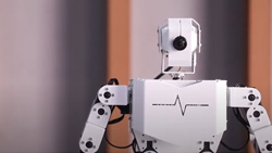 A closeup of a white and black humanoid robot torso with one eye.