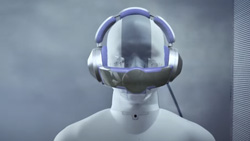 A gray set of headphones with a bracket that fits over the mouth is on a mannequin.