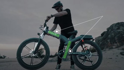 A person is getting ready to get on a rugged-looking ebike on a rocky beach