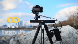 A camera is mounted on a tripod outdoors.