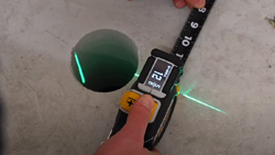 A person is using a digital tape measure.