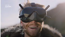 A person facing the camera is wearing a FPV headset and smiling