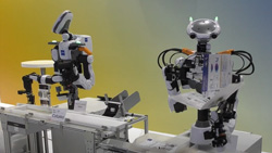 Two humanoid robots on an assembly line.