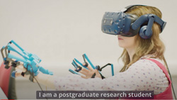 a person with a VR headset and haptic gloves is reaching out. The text reads I am a post-graduate research student