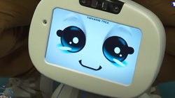 A closeup of a white robot's oval head that has a LCD screen for a face. It has large eyes and a mouth that is displaying a happy emotion.