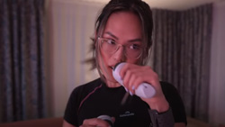 A closeup of a person in a boxing pose holding white gaming controller devices in their hands.