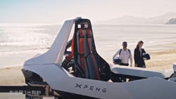 A white one-seat, open-cockpit craft sits in the foreground while two people holding helmets approach from the distance.
