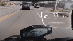 A view from inside a smart motorcycle helmet shows a street with cars and the motorcycle dash display. An overlay shows speed and an arrow indicating the distance to and direction of the next turn as well as a phone icon. Text reads 33MPH and Incoming Call.