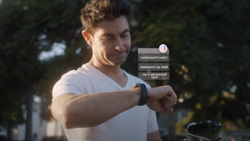 a person is looking at their watch, in a park-like setting, and a holographic representation hovers above the watch