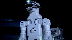 A closeup of a white and black robot's torso, arms and head.