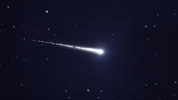 A shooting star with a long tail in the dark night sky