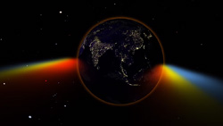 A darkened view of Earth from space with a rainbow of colors eminating from the equator