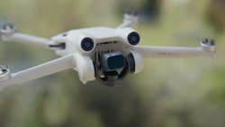 A white drone in mid-air.