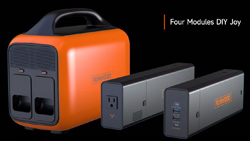 An orange and black power station about the size and shape of a small cooler with 2 extra rectangular battery packs on the side.