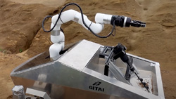 A closeup of a wheelbarrow sized, 4-wheeled silver metal cart with a robotic arm at the top.