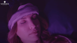 A darkened closeup of a person sleeping, wearing a headband.