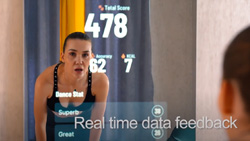 A person in workout clothes is looking in a mirror with statistics overlaid on the mirror. Text reads Real Time Data Feedback