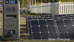 a power generator shaped like a desktop PC but larger sitting on lawn next to an array of small solar panels