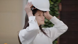 A chest high view of a person in white putting on a white helmet.