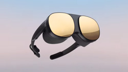 A closeup of a pair of bulky black glasses with gold reflective lenses floating in the sky