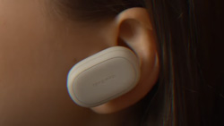 A closeup of a person wearing a device in their ear that looks like a large capsule shaped earbud