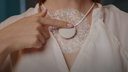 A person is pressing a button on a device worn as a necklace